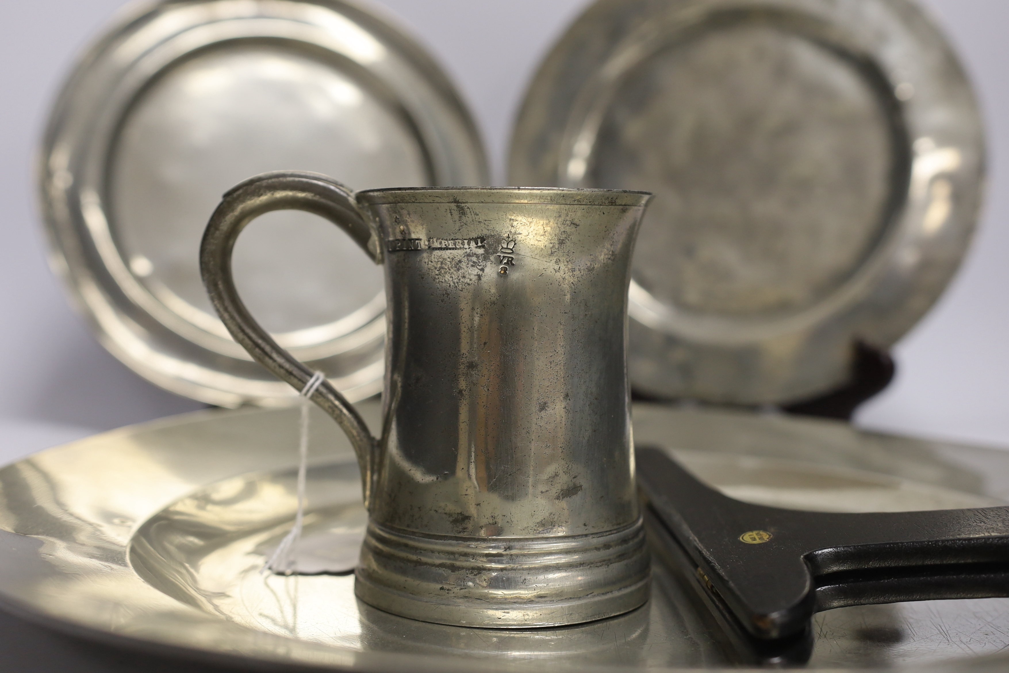 Four 18th century and later pewterware items including a charger, 41.5cm diameter, two plates, and a mug